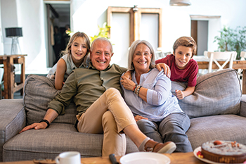 A family sitting on the couch together. Links to Gifts from Retirement Plans