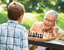 Photo of a man playing chess with his grandson. Links to Tangible Personal Property